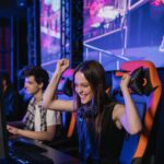 Young woman celebrating a win while playing video games at an esports event.